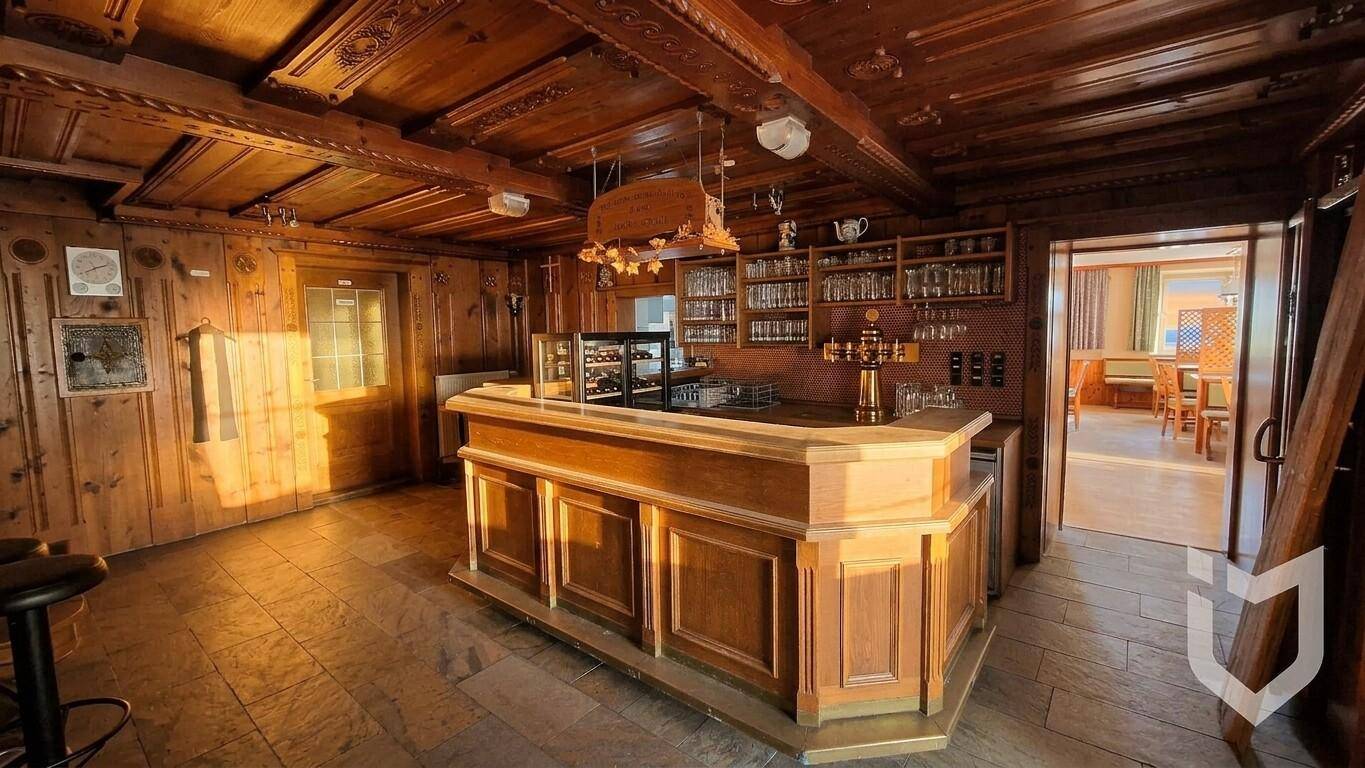 Rustikaler Barbereich mit Holztäfelung, Theke und traditioneller Einrichtung.