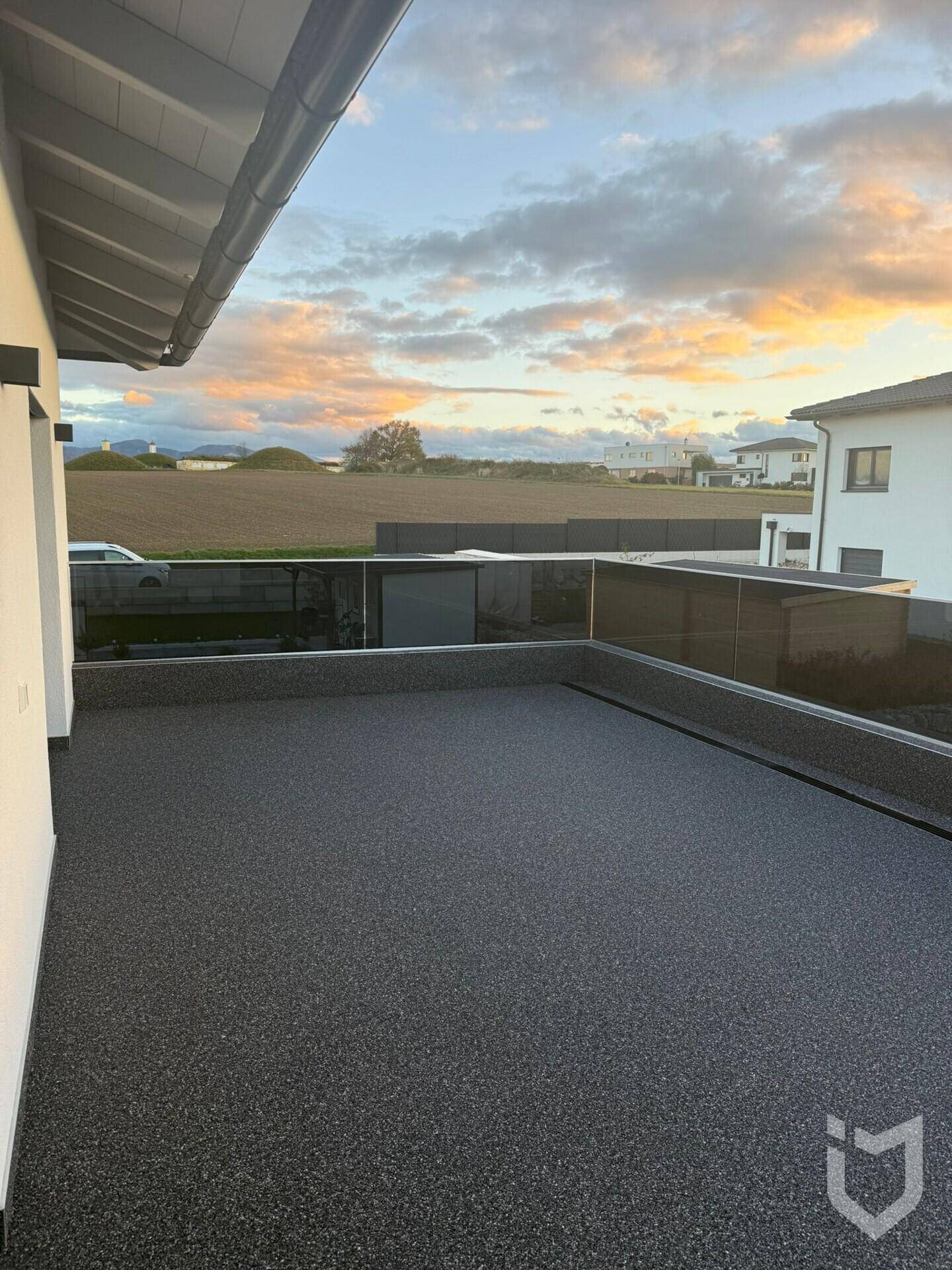 Dachterrasse bei Sonnenuntergang mit weitem Blick über die ländliche Umgebung.