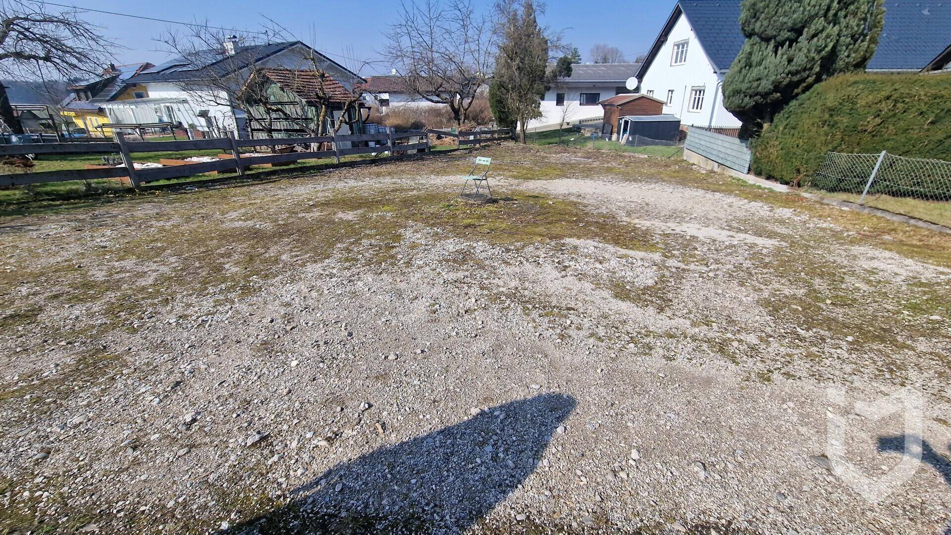 Großes, unbebautes Grundstück mit Schotter und Gras, umgeben von ländlicher Bebauung.