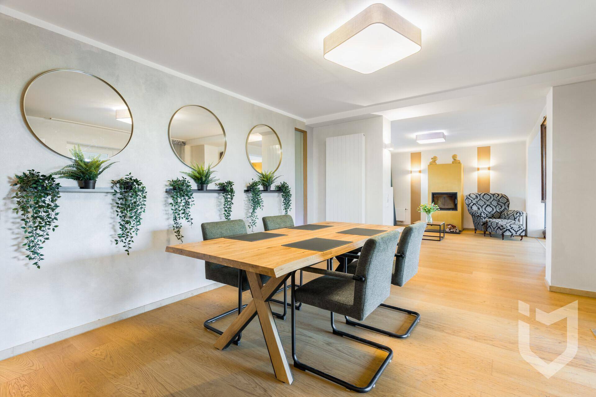 Heller Essbereich mit Holztisch, modernen Stühlen und dekorativen Spiegeln an der Wand.