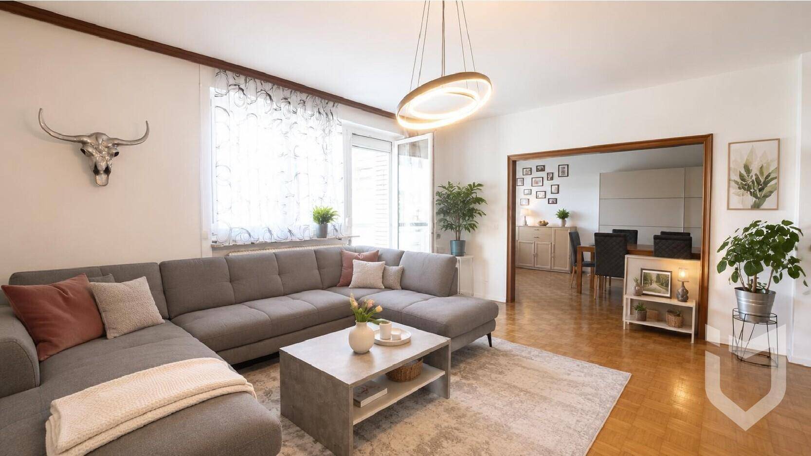 Gemütliches Wohnzimmer mit großem Ecksofa, modernem Couchtisch und Zugang zum Essbereich.