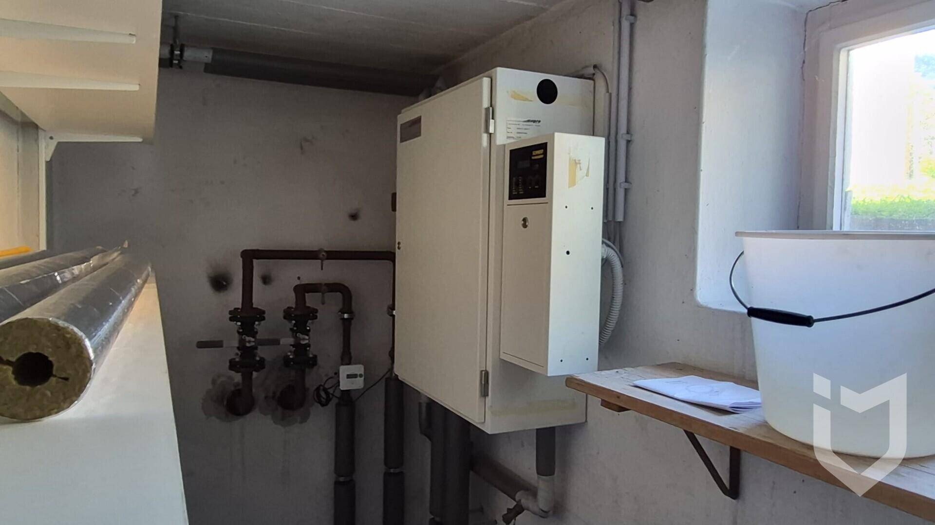 Heizraum im Keller mit moderner Heizungsanlage und sichtbaren Rohrleitungen.