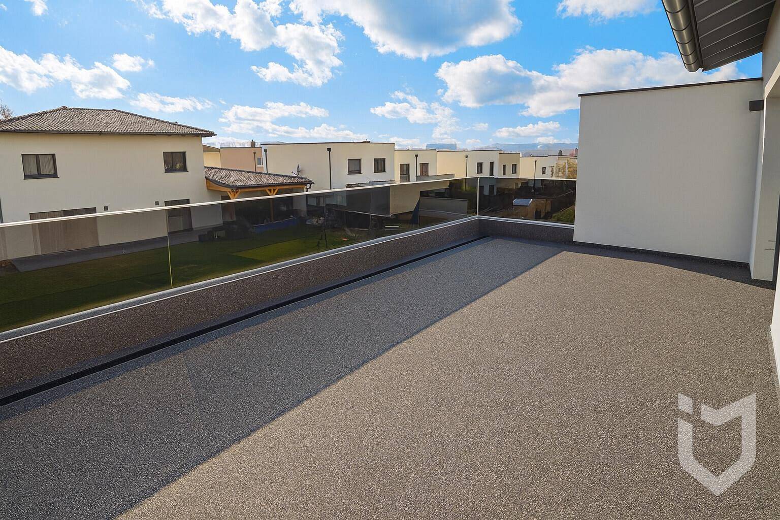 Große Dachterrasse mit modernem Glasgeländer und weitem Blick über die Nachbarschaft.