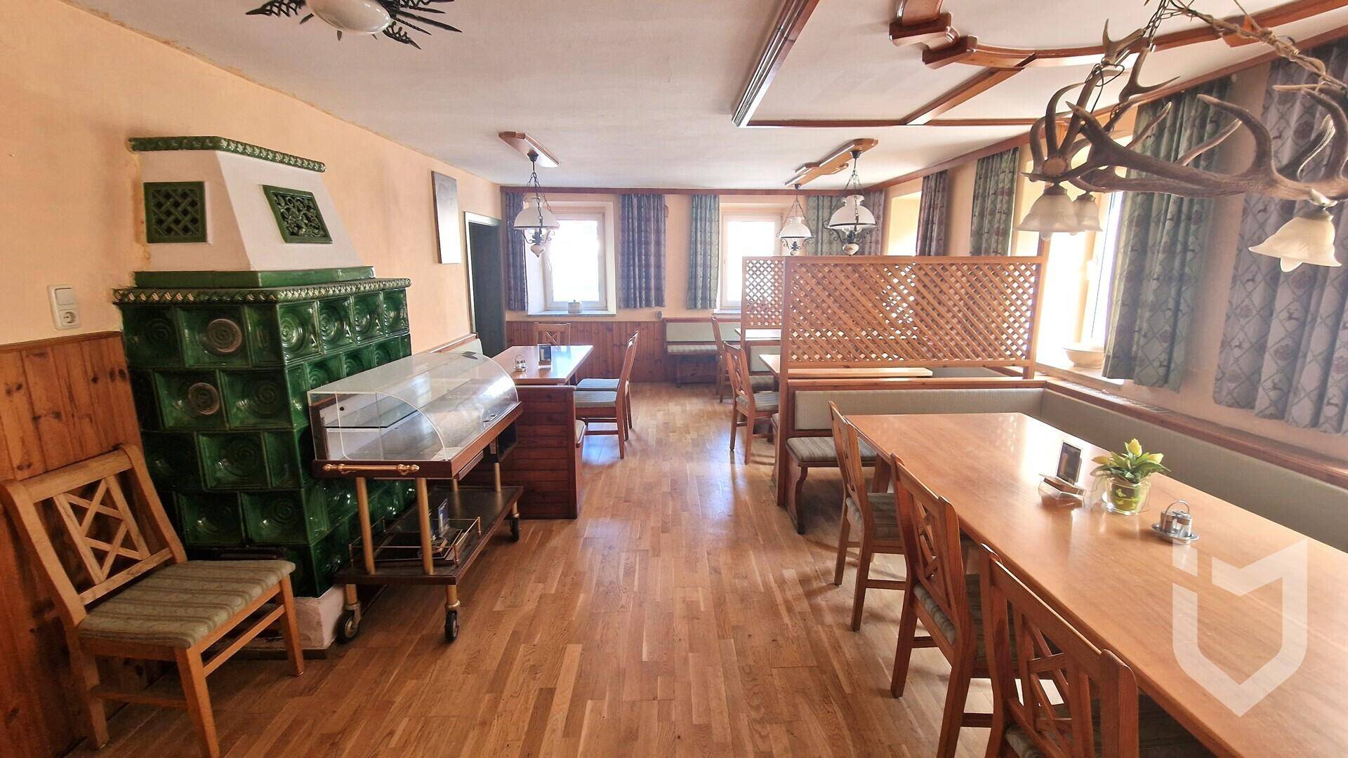 Traditioneller Essbereich mit Kachelofen, Holzböden und rustikalen Möbeln.