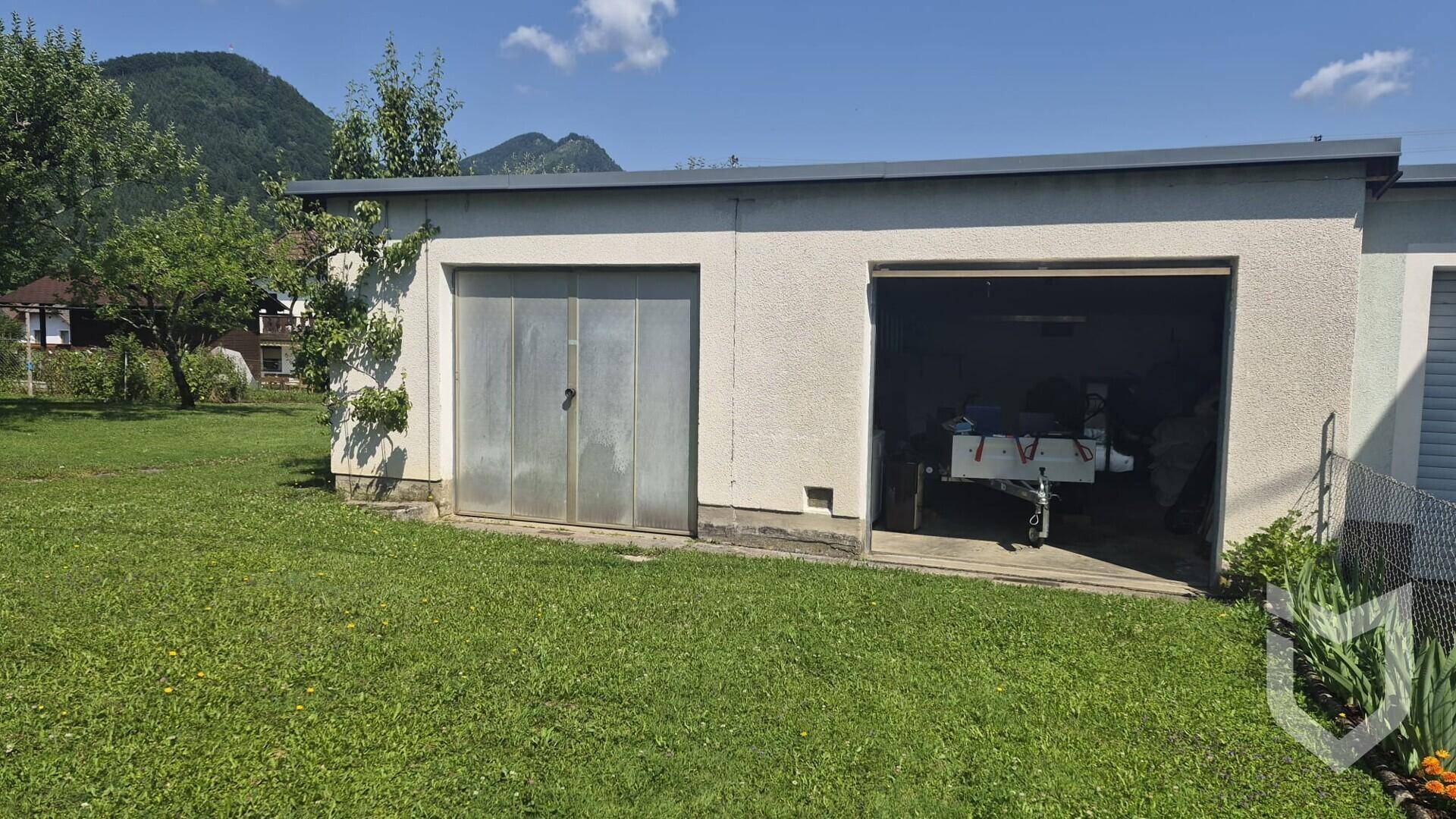 Freistehende Doppelgarage mit Stauraum und Zugang zum Gartenbereich.
