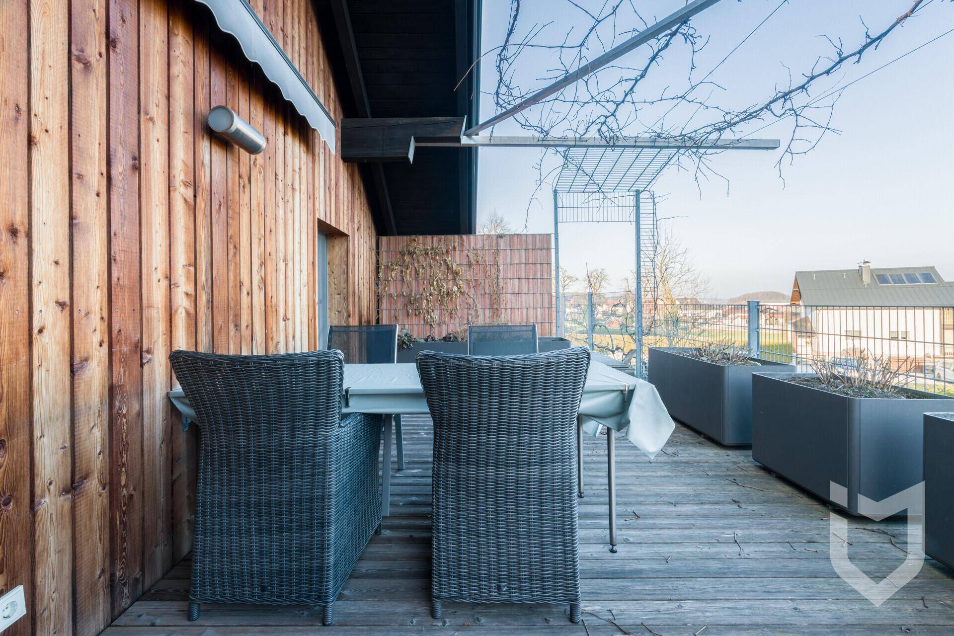 Holzterrasse mit Esstisch und Stühlen, ideal für Mahlzeiten im Freien.