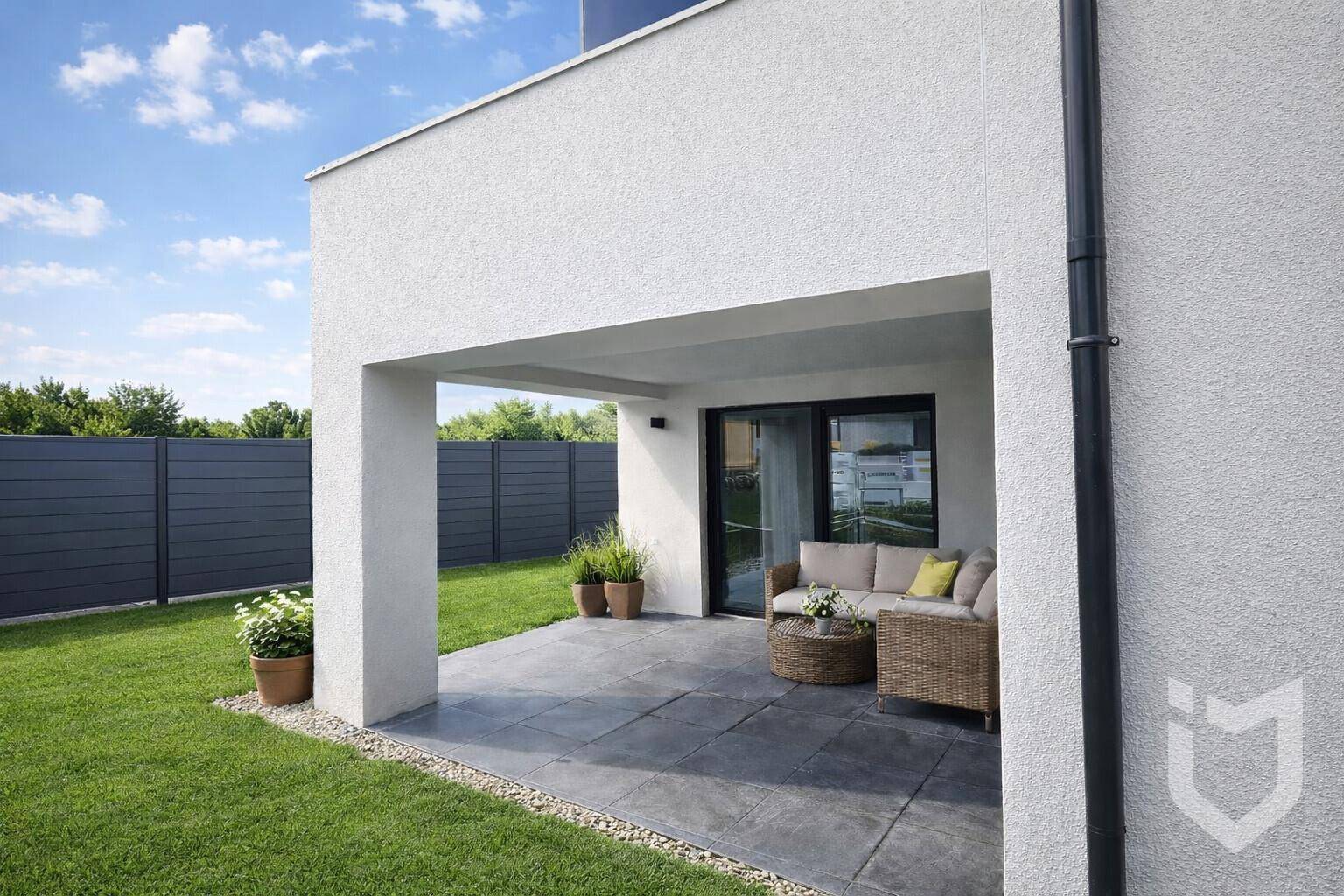Überdachte Terrasse mit Sitzgelegenheiten und Zugang zum gepflegten Rasengarten.