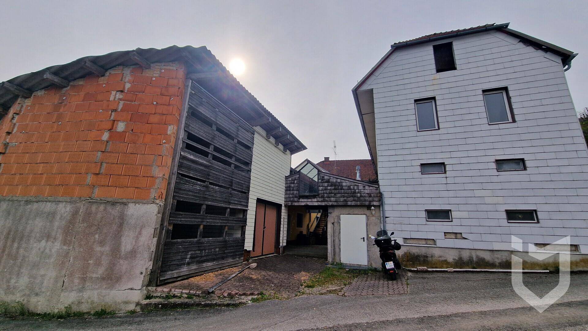 Verschiedene Gebäude auf dem Grundstück, darunter eine alte Scheune und ein Wohnhaus.