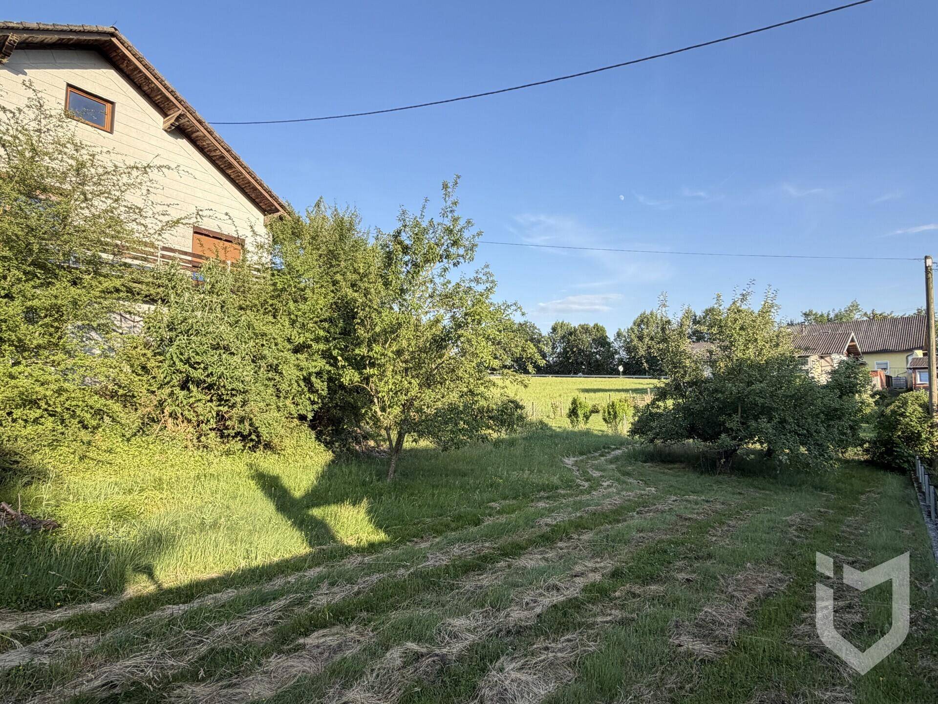 Großer Gartenbereich neben dem Einfamilienhaus mit Blick auf die umliegende Landschaft.