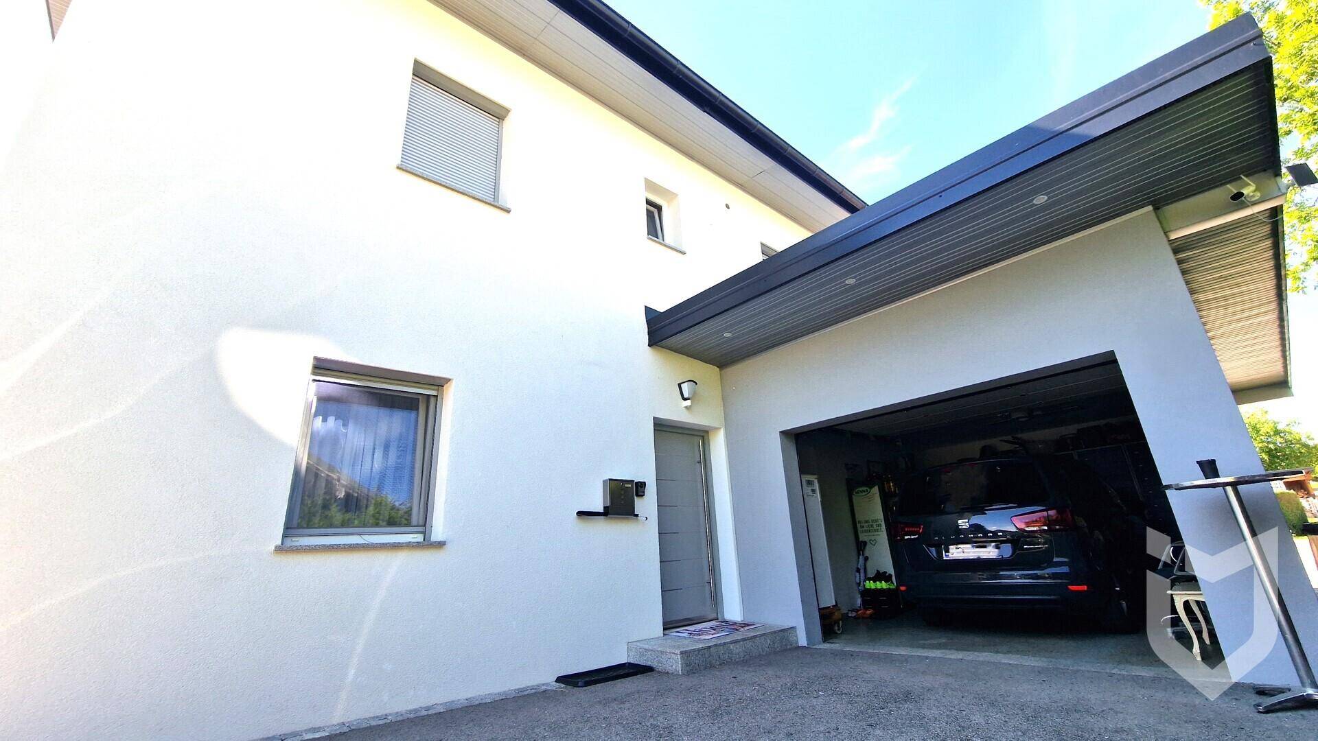Eingangsbereich des Hauses mit integrierter Garage und modernem Vordach.