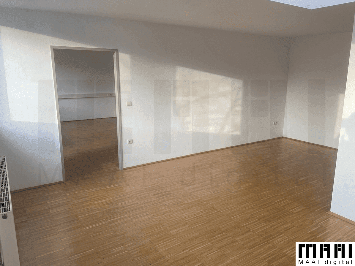 Geräumiger, heller Raum mit Holzparkettboden und weiß gestrichenen Wänden, mit Zugang zu einem weiteren Zimmer.