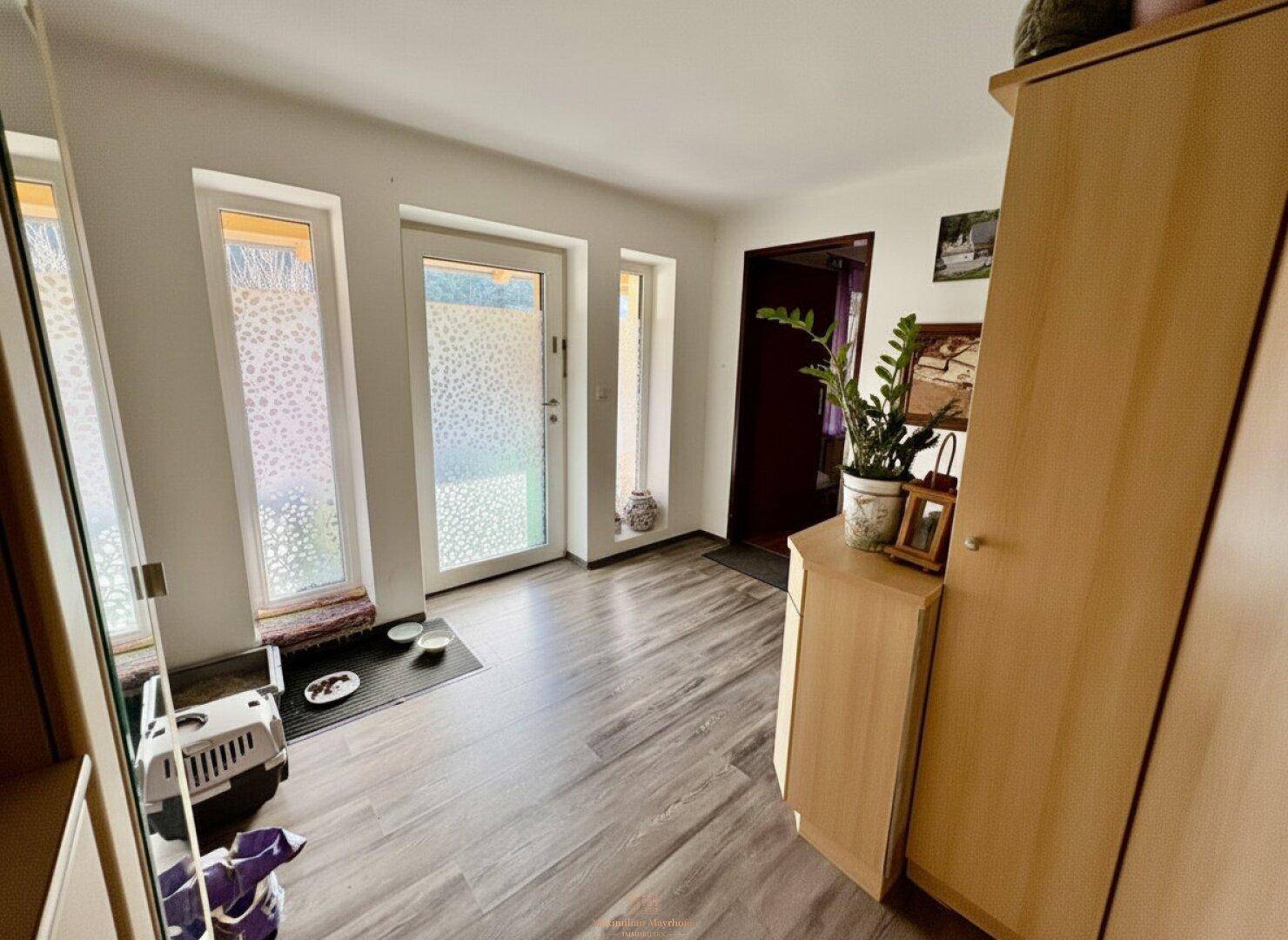 Heller Eingangsbereich mit Laminatboden und Garderobenschrank, führt zu den weiteren Räumen.