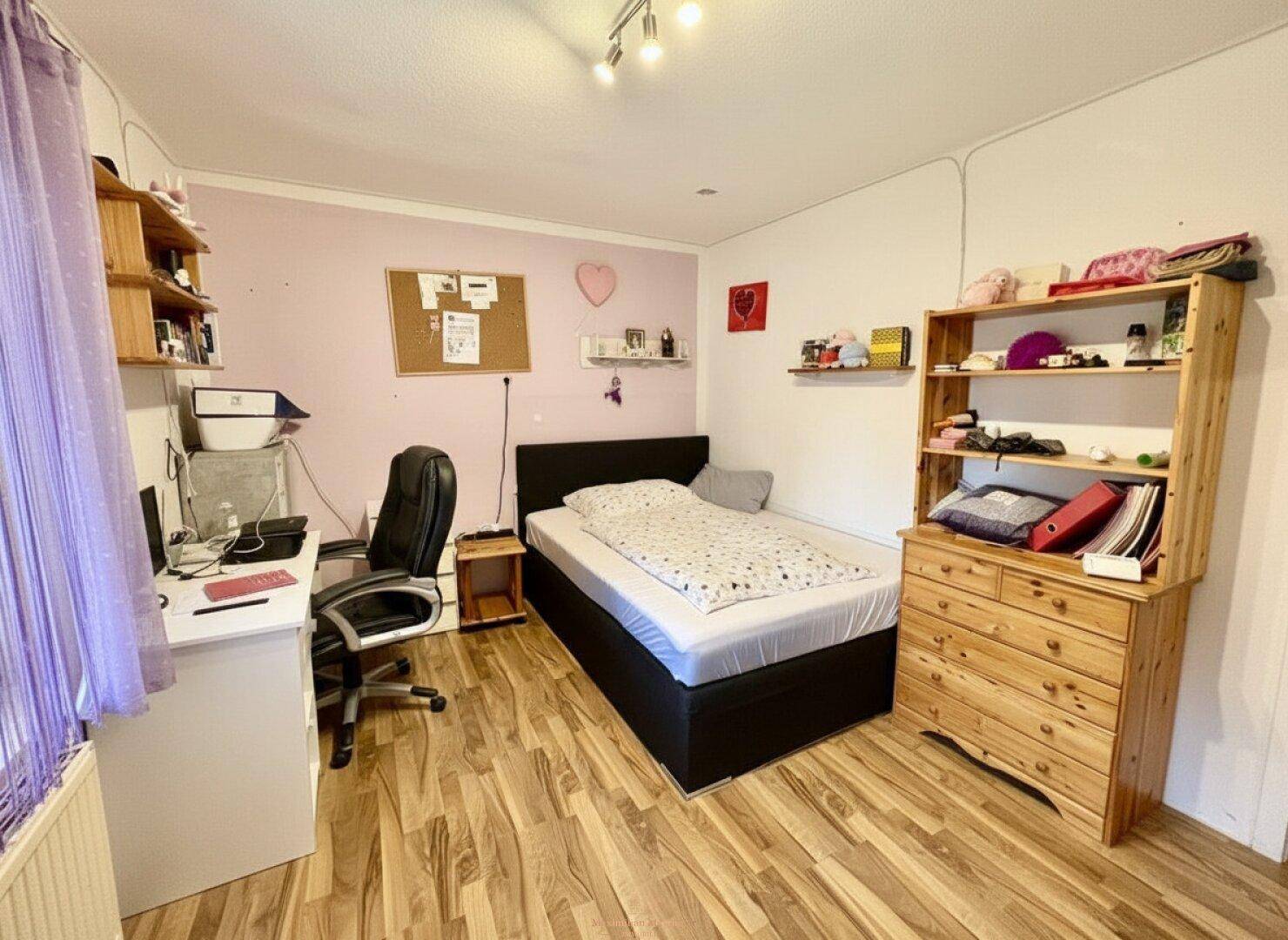 Schlafzimmer mit Einzelbett, Schreibtisch und Holzregalen, ideal als Jugend- oder Gästezimmer.