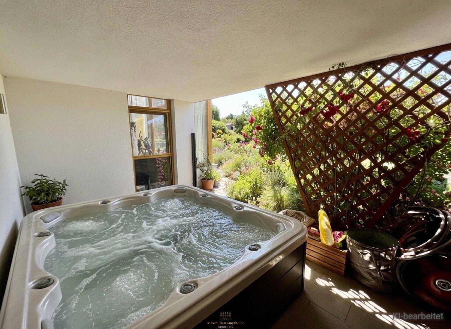 Überdachte Terrasse mit Whirlpool und Blick ins Grüne, umgeben von Rosen und Pflanzen.