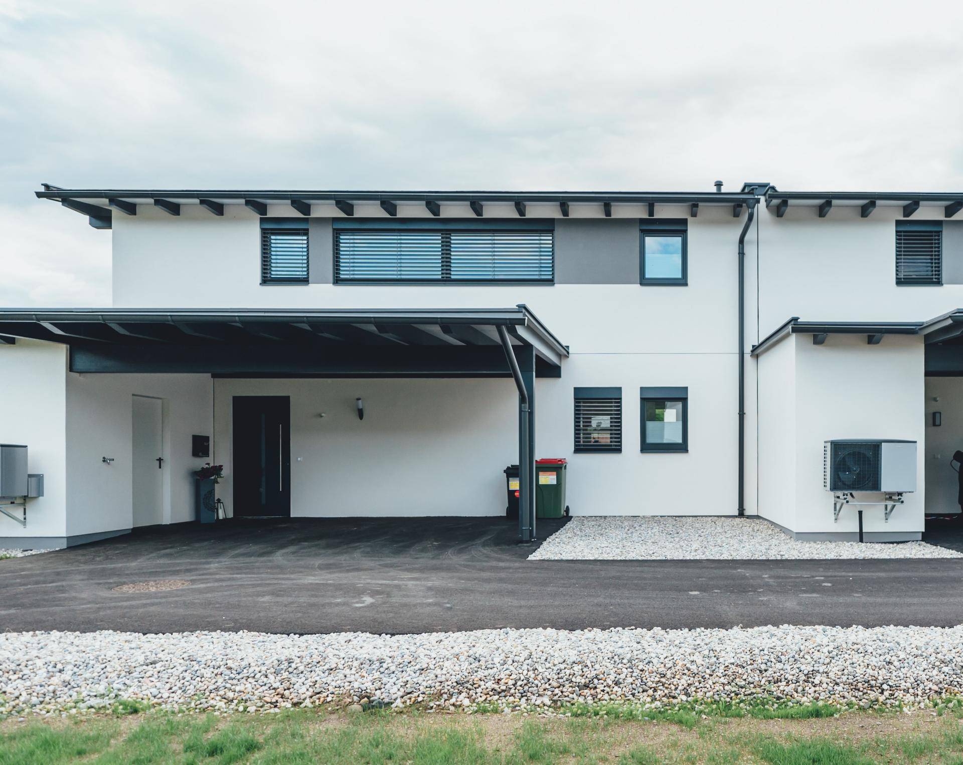 Moderne Reihenhäuser mit Carports, gepflegter Zufahrt und Außenanlagen.