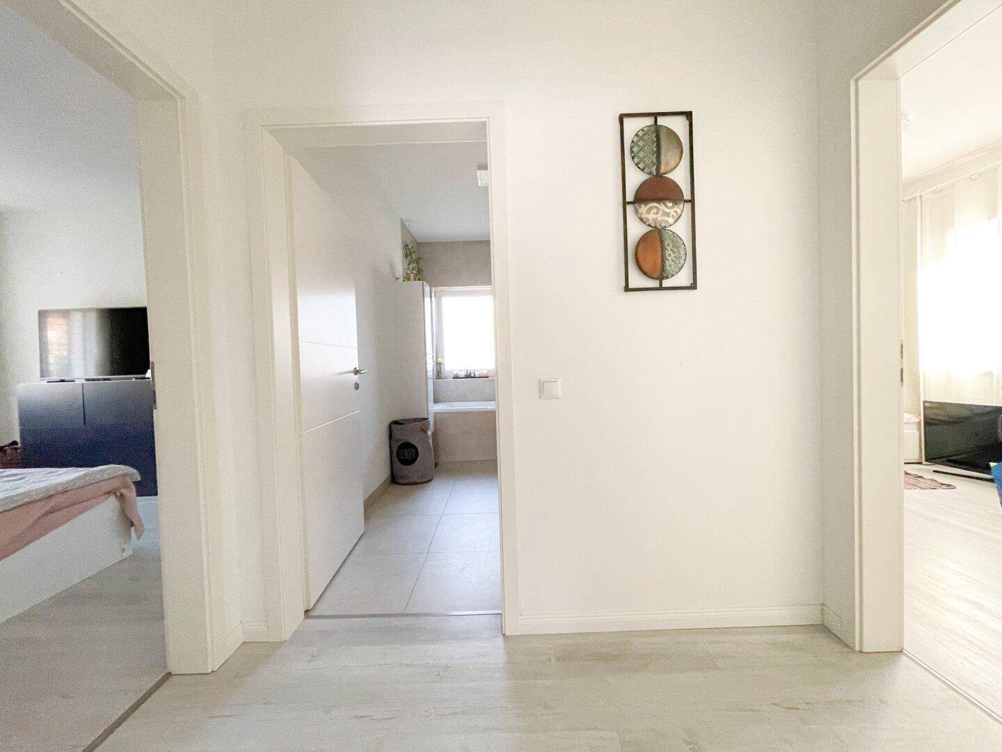 Heller Flur mit Zugang zu verschiedenen Zimmern, modern und schlicht gestaltet.