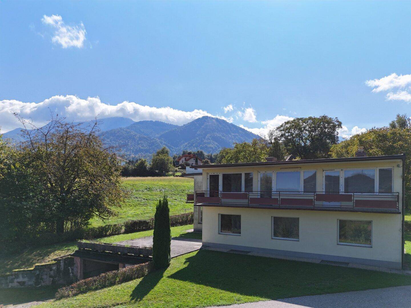 Rückansicht des Hauses mit Balkonen und weitem Blick auf die umliegende Berglandschaft.