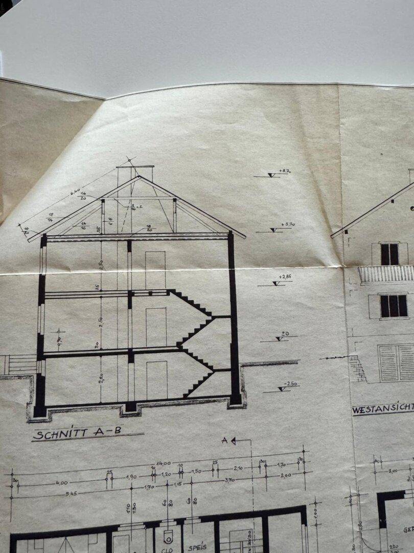 Schnittzeichnung des Gebäudes zeigt die vertikale Struktur mit Keller und Stockwerken.