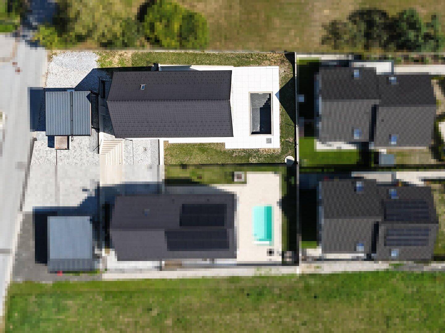 Luftaufnahme mehrerer moderner Häuser mit Pools und umliegender Landschaft.