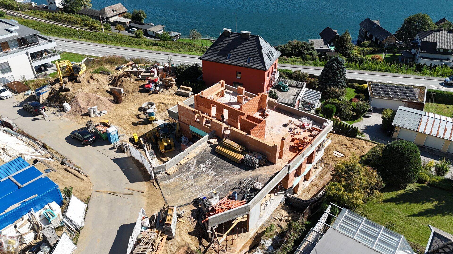Nahaufnahme einer Baustelle mit einem im Bau befindlichen Gebäude direkt am See.