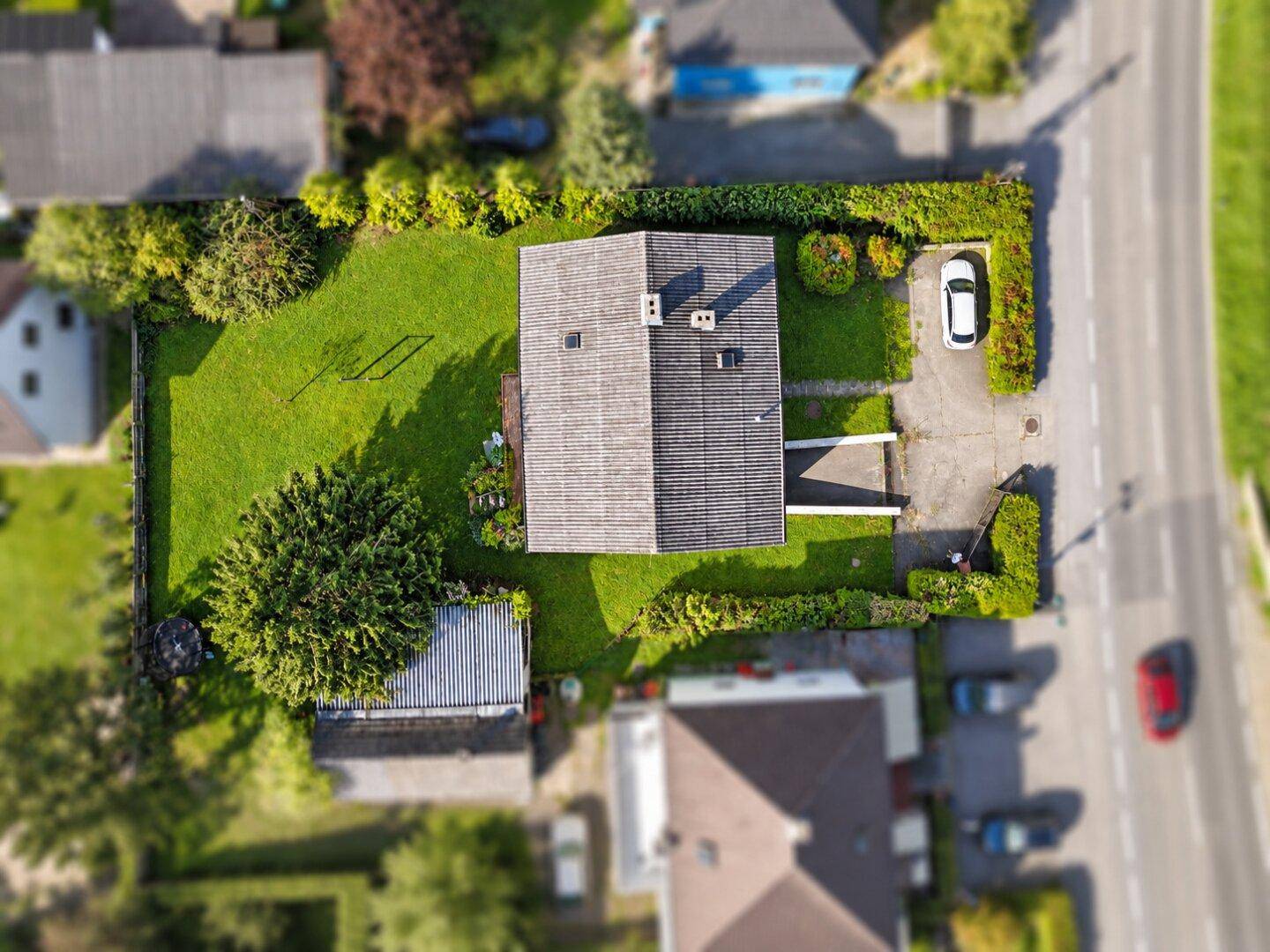 Draufsicht auf das Wohnhaus mit großem Garten, Rasenfläche und Zufahrt in einer ruhigen Wohngegend.