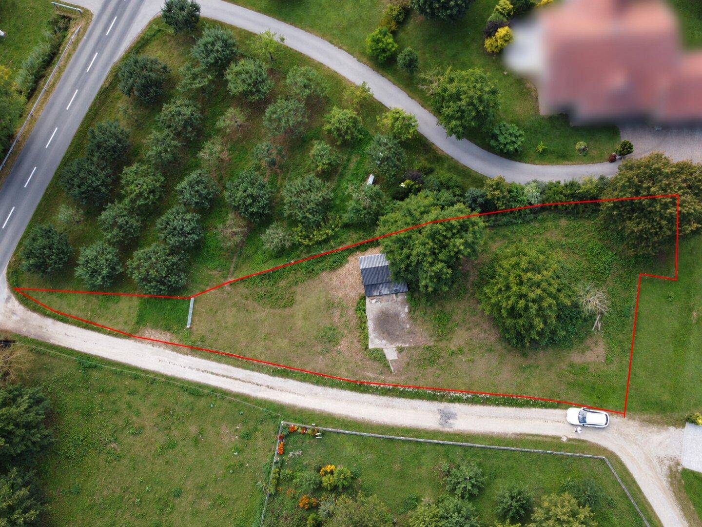 Übersicht aus der Vogelperspektive mit Grundstücksgrenzen, angrenzender Straße und viel Grünfläche.