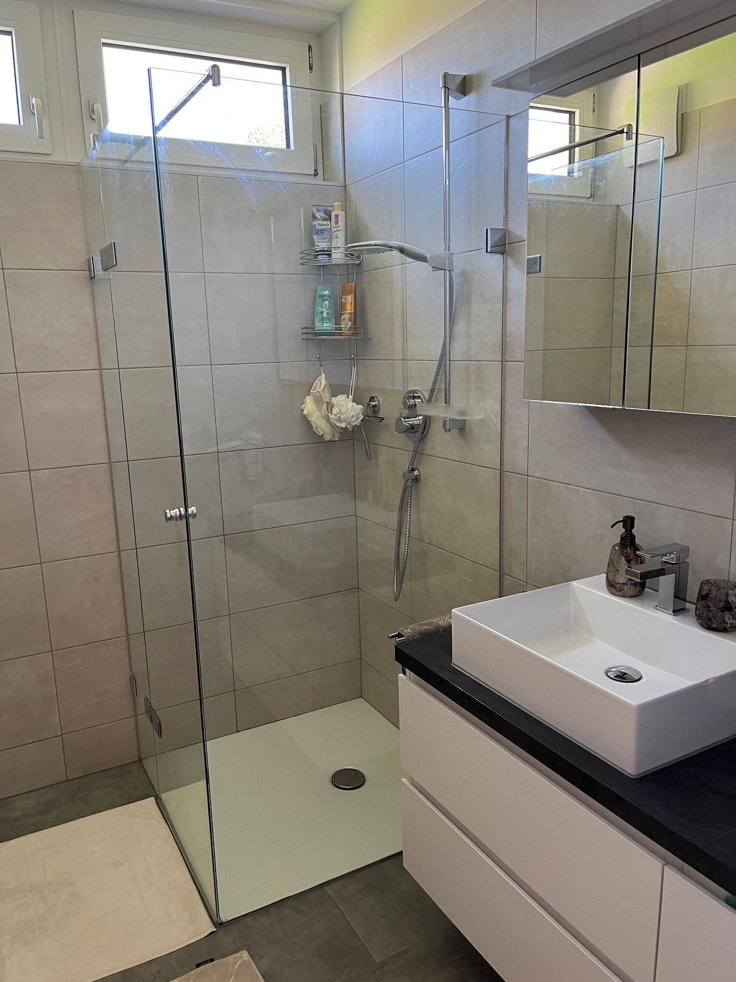 Modernes Badezimmer mit begehbarer Dusche, Einzelwaschbecken und Fenster.