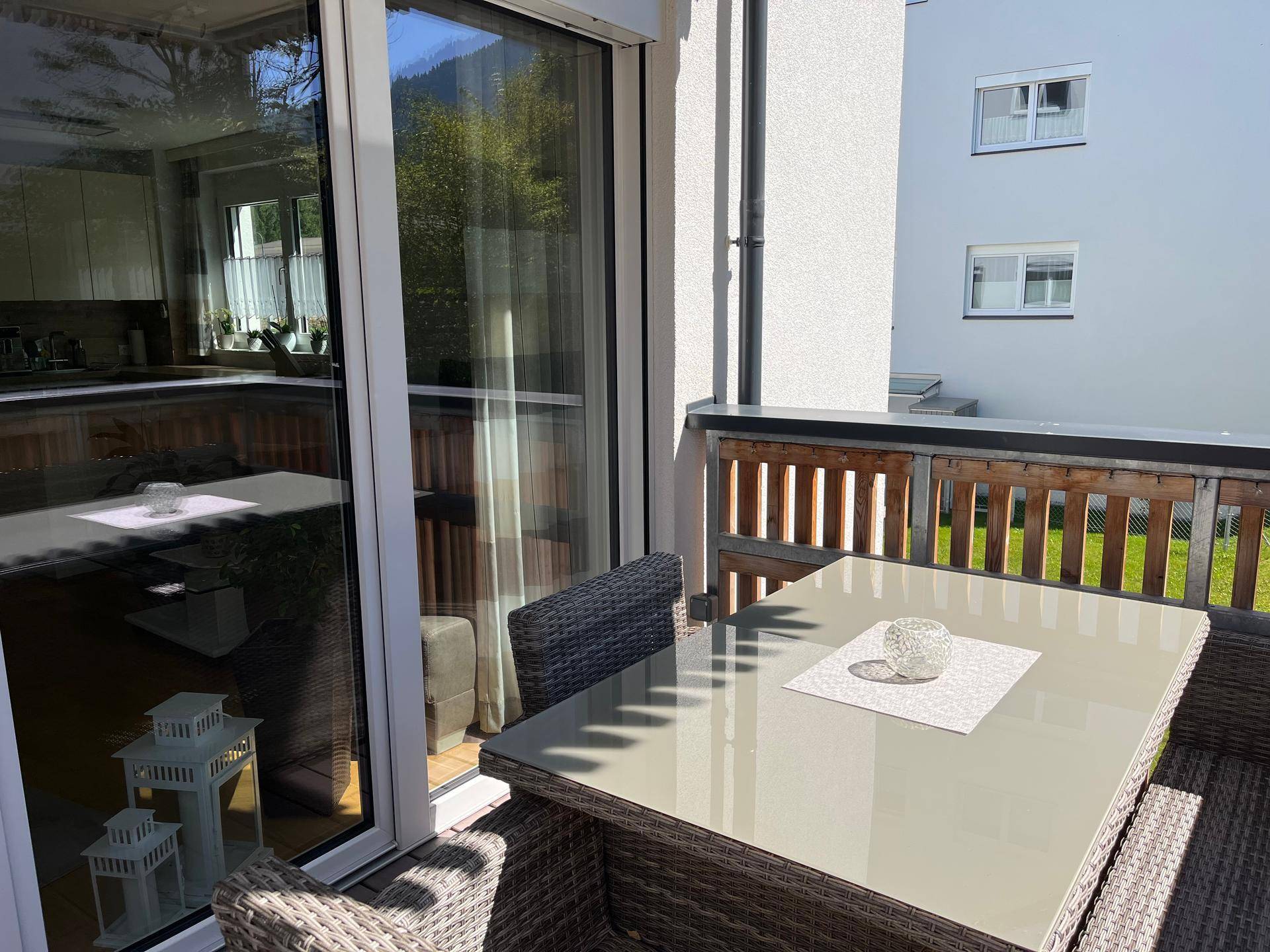 Geräumiger Balkon mit Sitzgelegenheiten und Zugang zum hellen Wohnbereich.