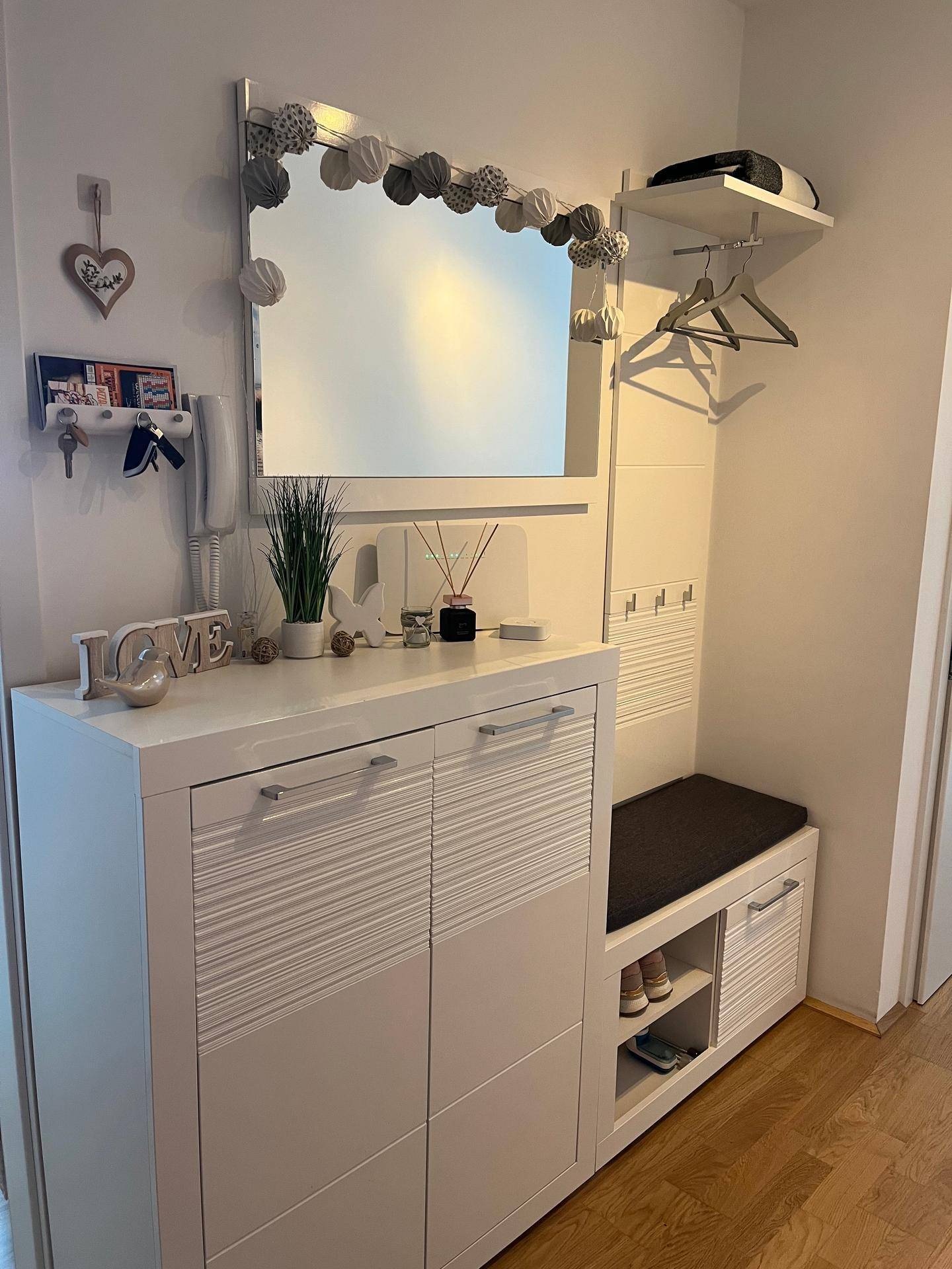 Moderner Flur mit Spiegel, Schuhschrank und integrierter Sitzbank.