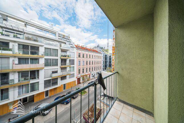 Balkon mit Blick auf die belebte Straße und die umliegenden Stadtgebäude.