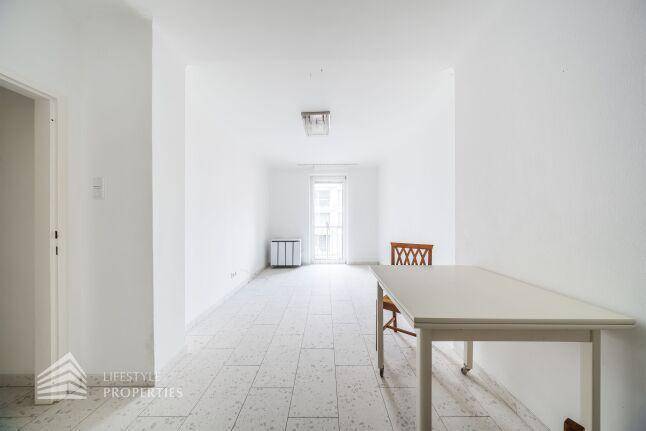 Langer Wohn-Essbereich mit Fliesenboden, Esstisch und Zugang zu einem französischen Balkon.