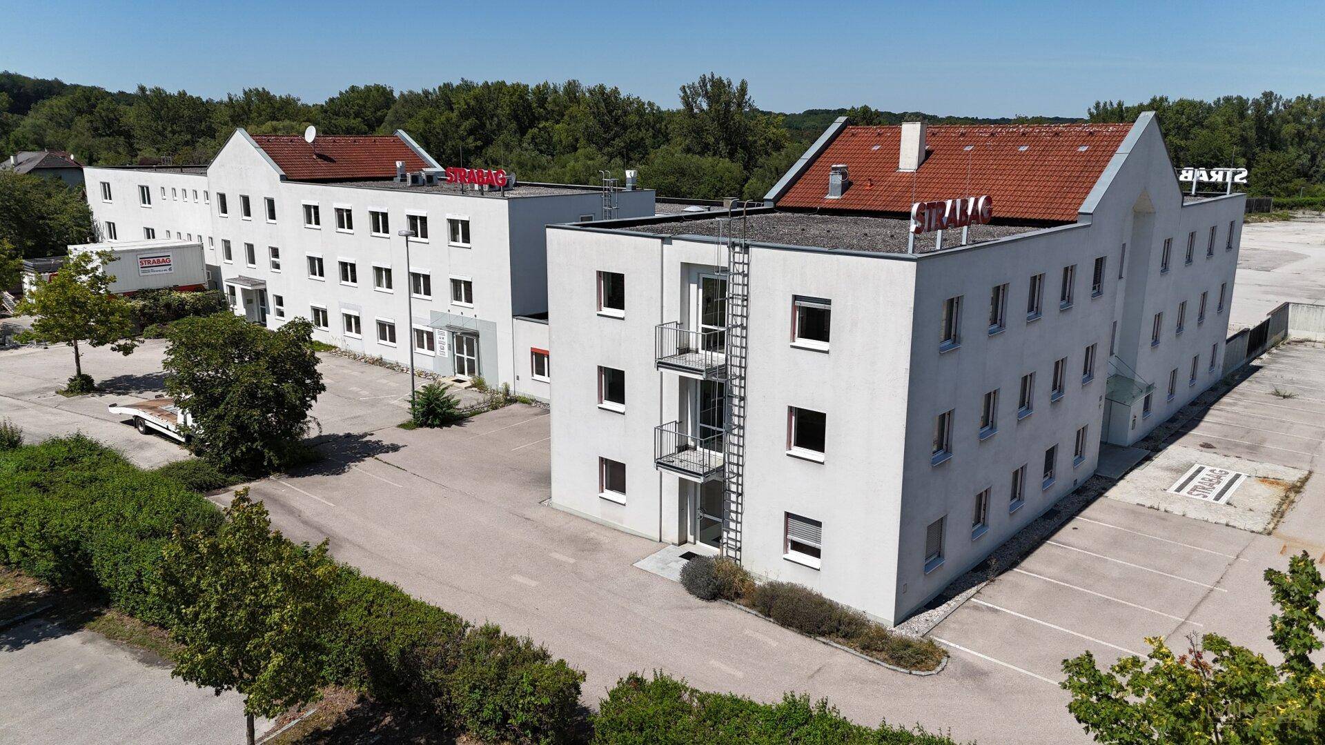 Überblick über mehrere Geschäftsgebäude mit Parkplätzen und einem Außentreppenhaus.