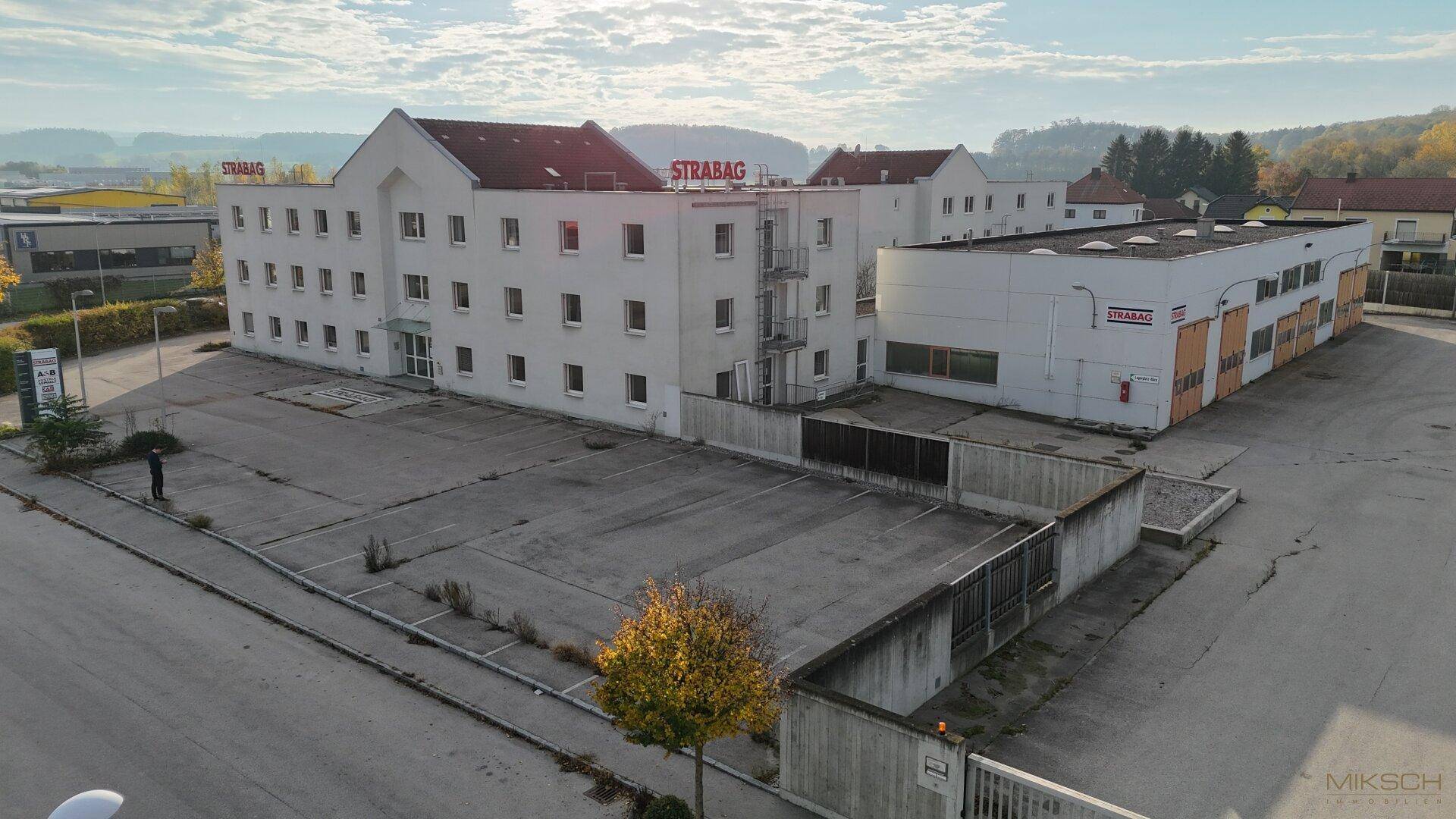 Weitläufige Ansicht des Geschäftsgeländes mit verschiedenen Gebäuden und großen Parkflächen.