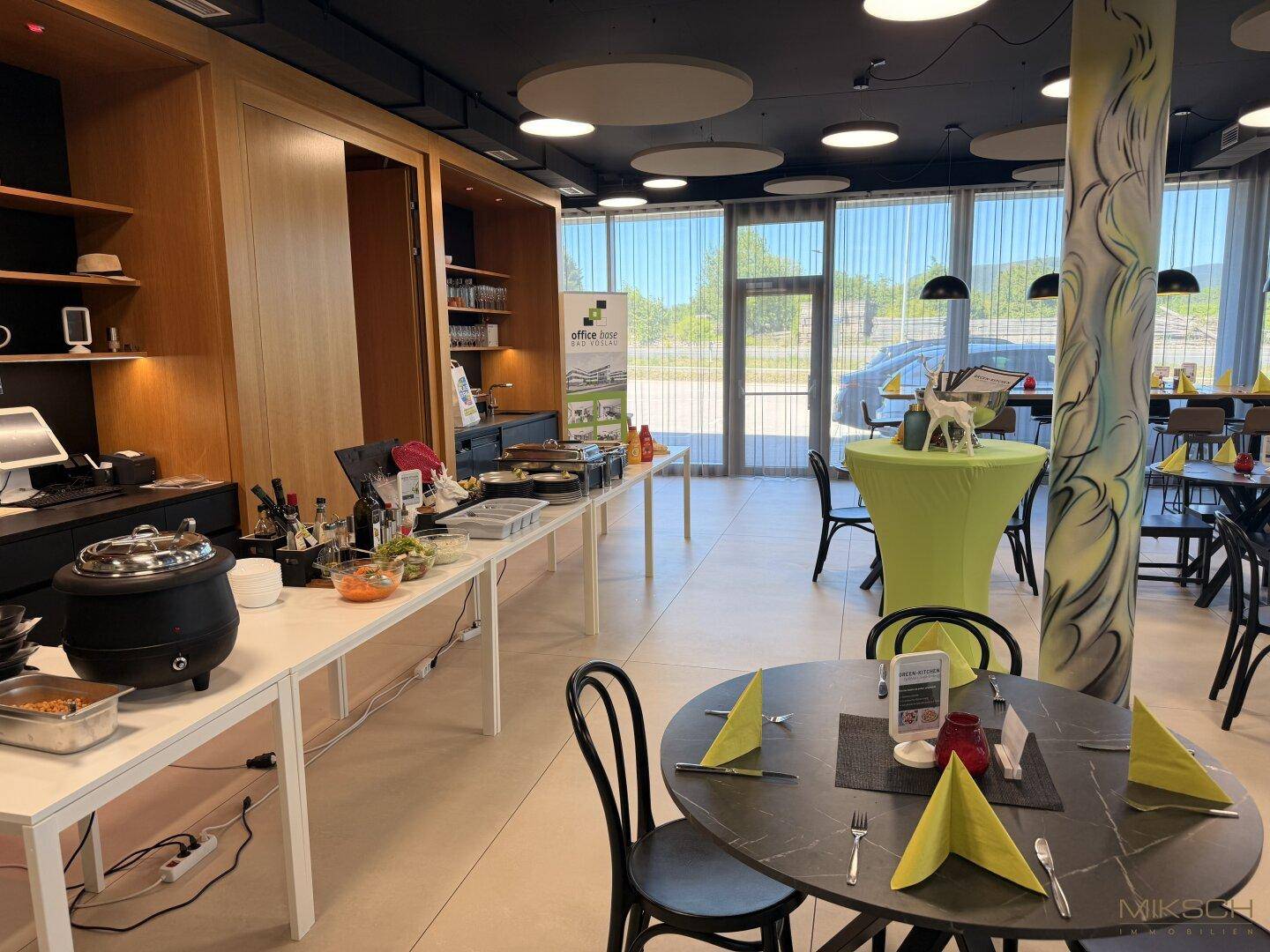 Großer Kantinenbereich mit Buffet, Tischen und Stühlen, ideal für Mitarbeitermahlzeiten und Veranstaltungen.