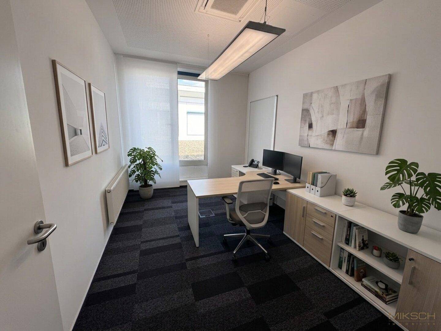 Einzelbüro mit modernem Schreibtisch, Bürostuhl, Computer und Pflanzen, gut beleuchtet durch ein Fenster.