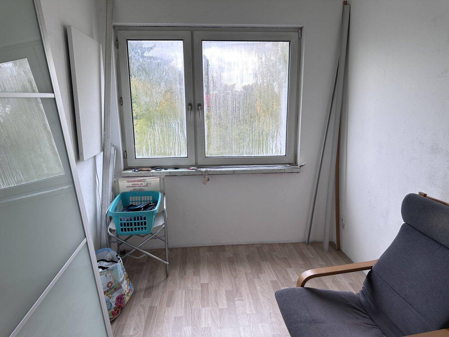 Kleiner Raum mit hellem Laminatboden und Fenster, ideal als Büro oder Abstellraum nutzbar.