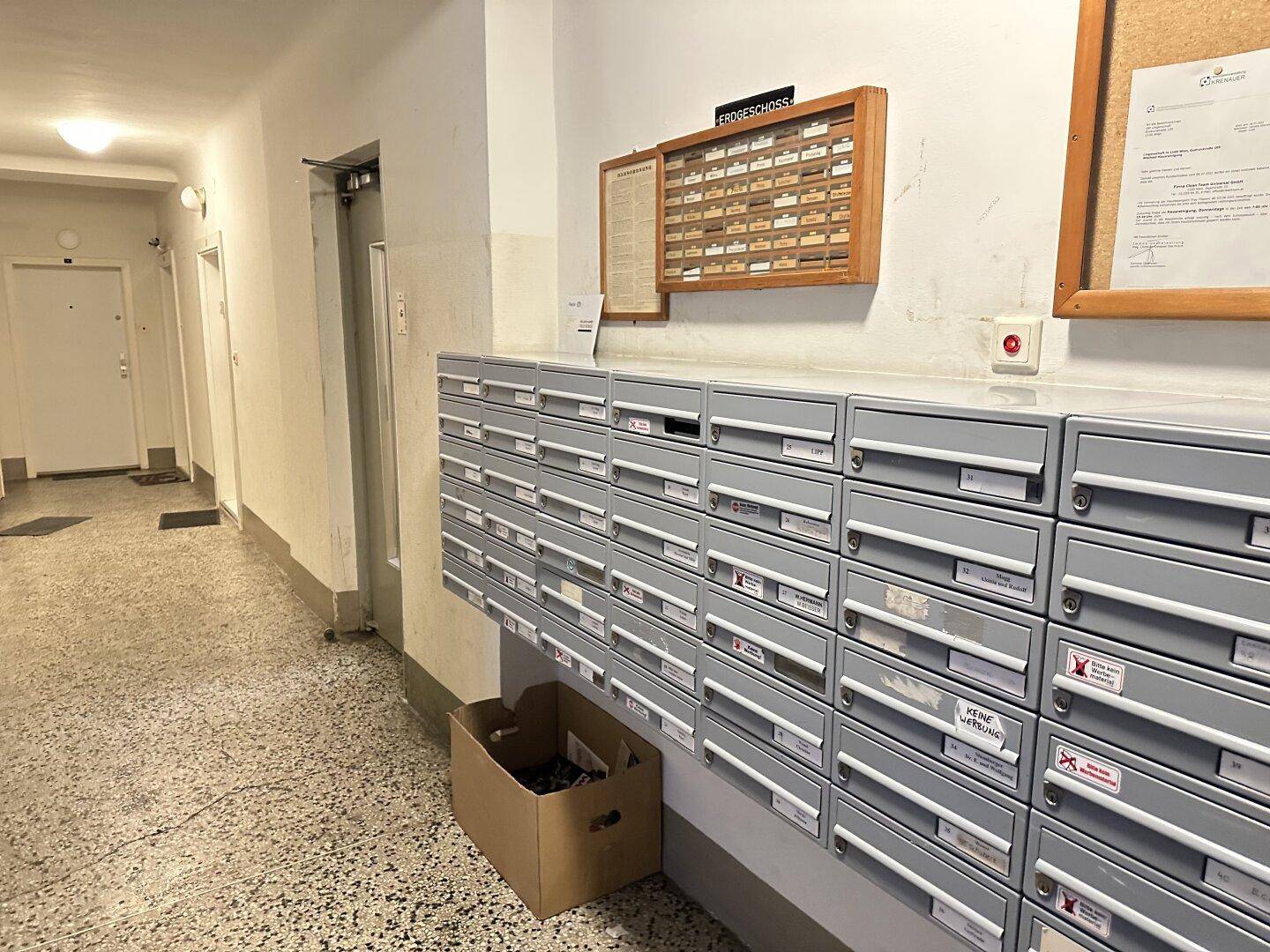 Eingangsbereich eines Mehrfamilienhauses mit Briefkästen und Zugang zum Flur.