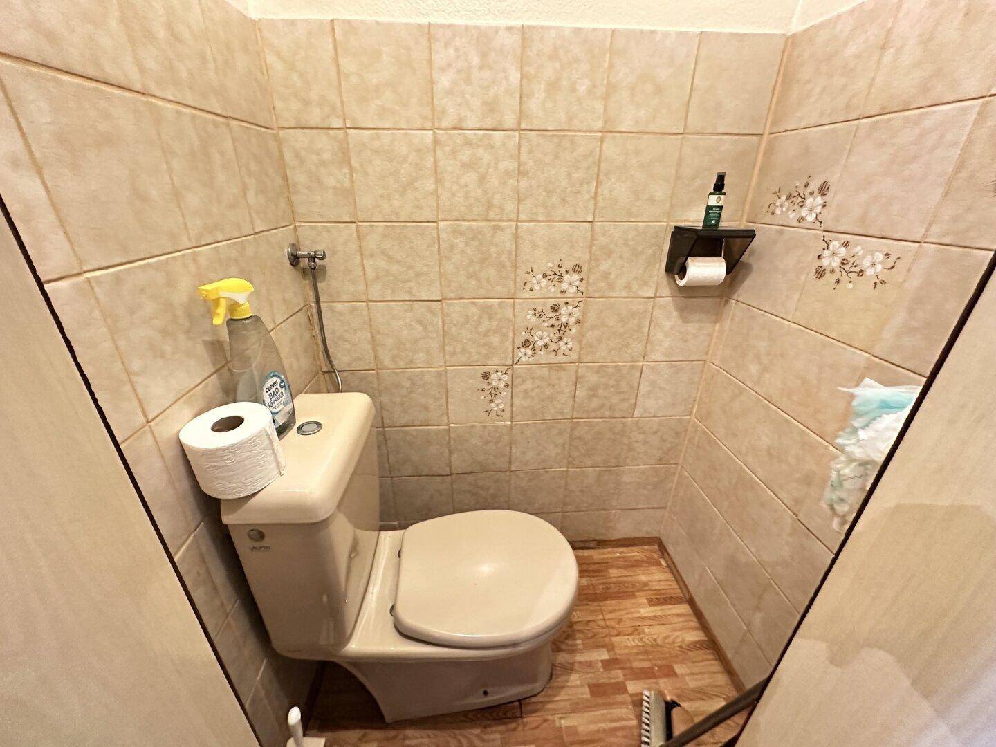 Kleines WC mit Toilette und hellen Fliesen im traditionellen Design.