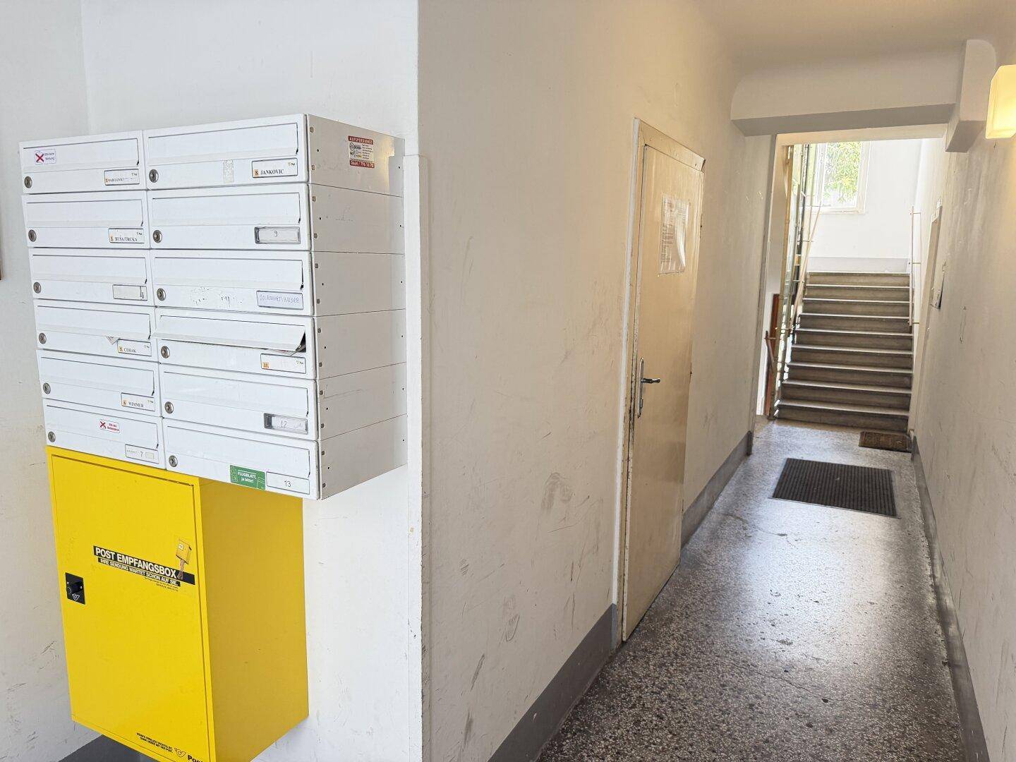 Eingangsbereich mit Briefkästen und Blick auf das Treppenhaus des Gebäudes.