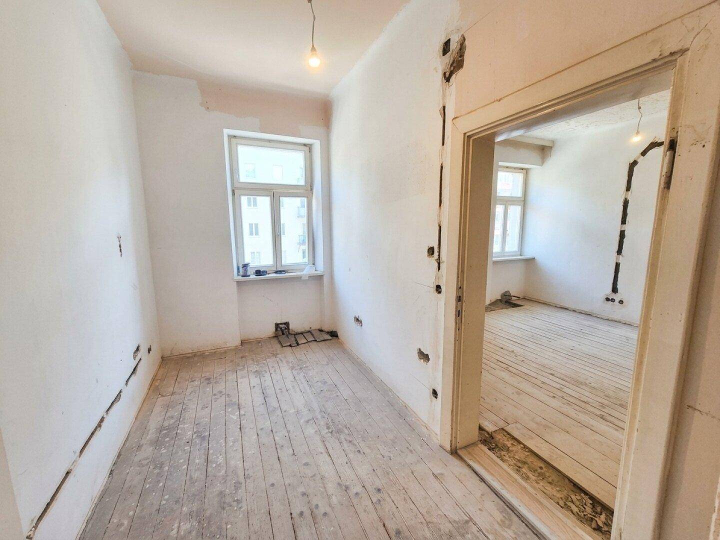 Weiterer Raum in Renovierung mit freigelegten Wänden und Holzboden, bietet Potenzial für individuelle Gestaltung.