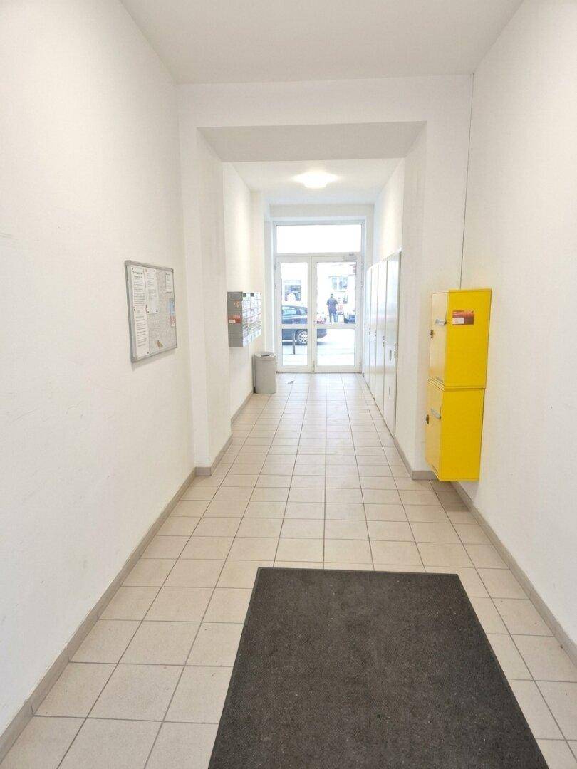 Geräumiger Eingangsbereich mit Fliesenboden, Briefkästen und Schließfächern, bietet Zugang zum Gebäude.