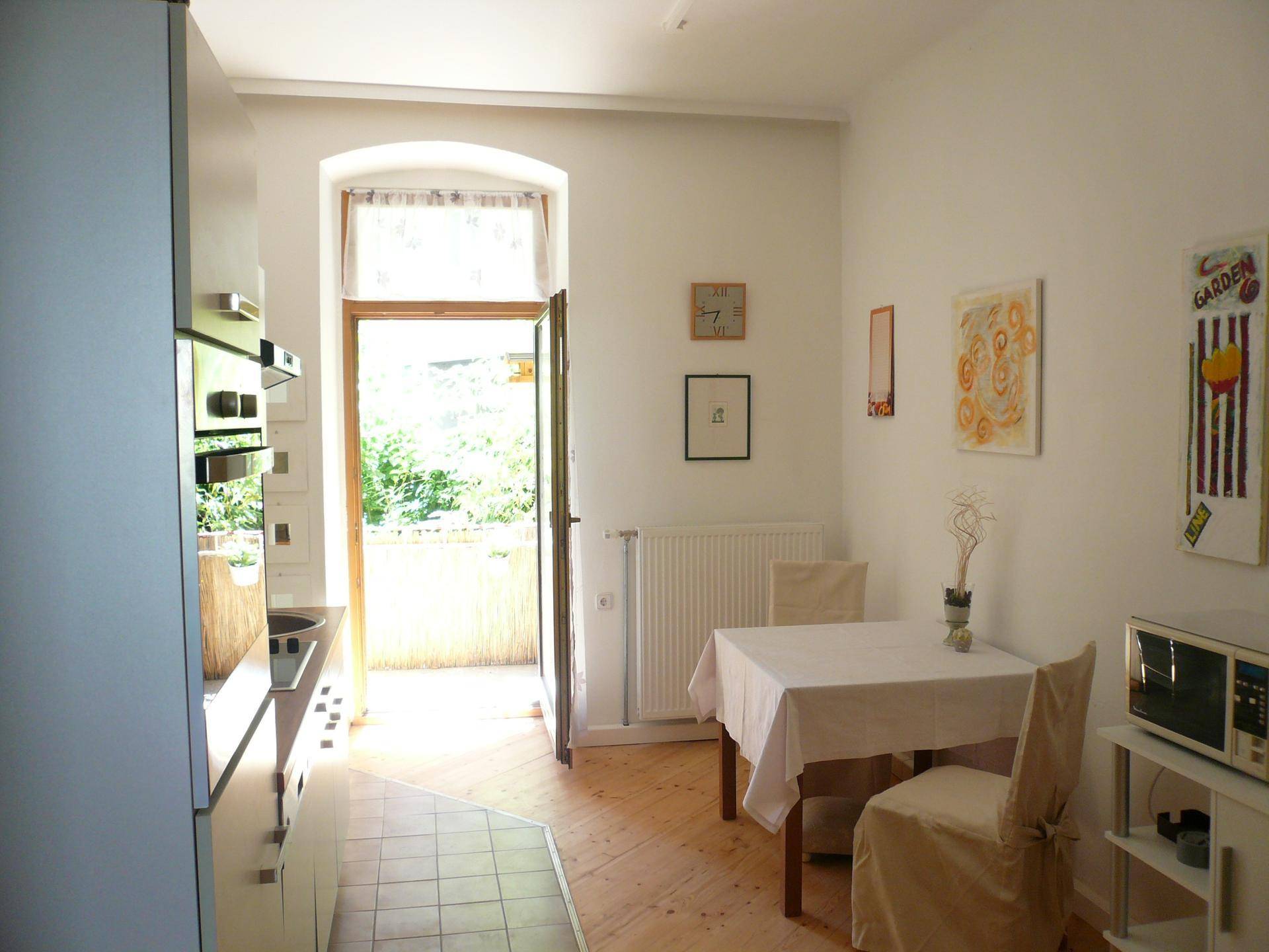 Essbereich in der Küche mit Zugang zu einem Balkon und viel Tageslicht.