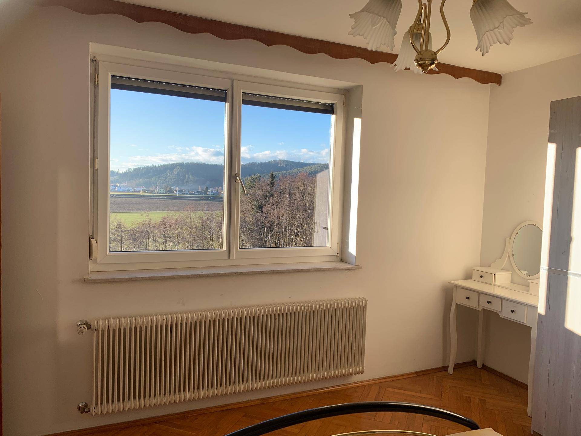 Zimmer mit weitem Blick auf die Landschaft und einem kleinen Schminktisch unter dem Fenster.
