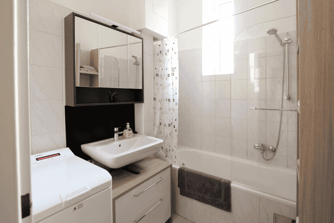 Badezimmer mit Badewanne, Dusche, Waschbecken und Spiegelschrank.