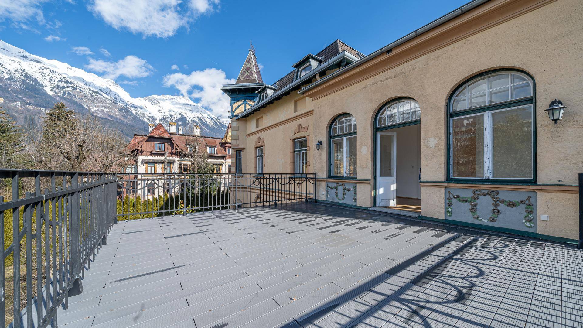 Große Terrasse mit Bergblick und historischer Fassade.