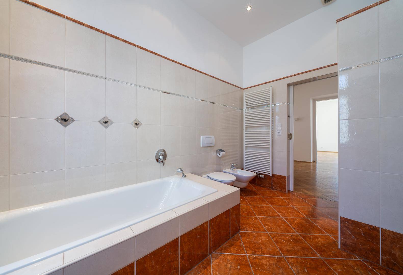 Geräumiges Badezimmer mit Badewanne, Bidet und Fliesenboden.