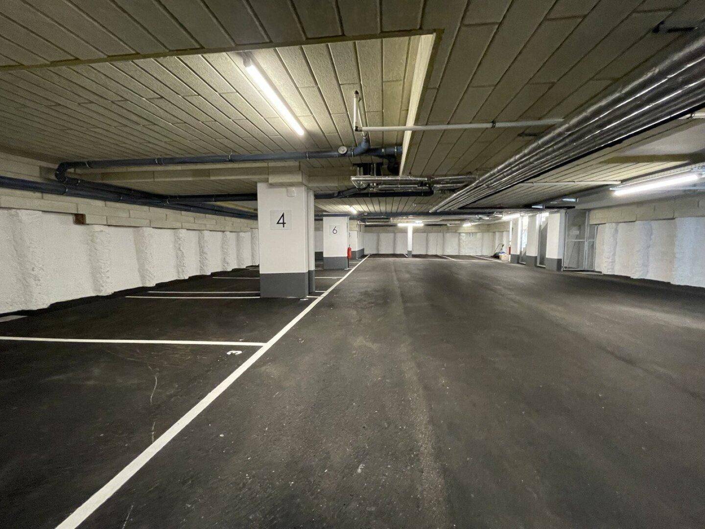 Geräumige Tiefgarage mit markierten Stellplätzen und guter Beleuchtung.