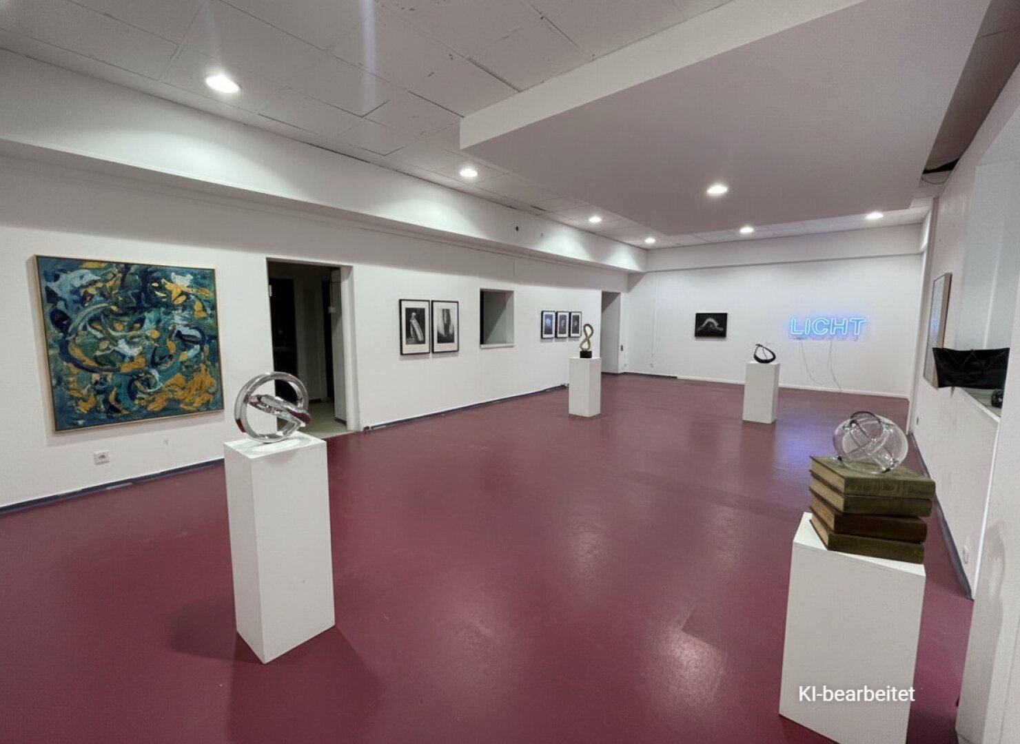 Moderne Kunstgalerie mit weiß gestrichenen Wänden und rotem Boden, präsentiert verschiedene Skulpturen und Gemälde.