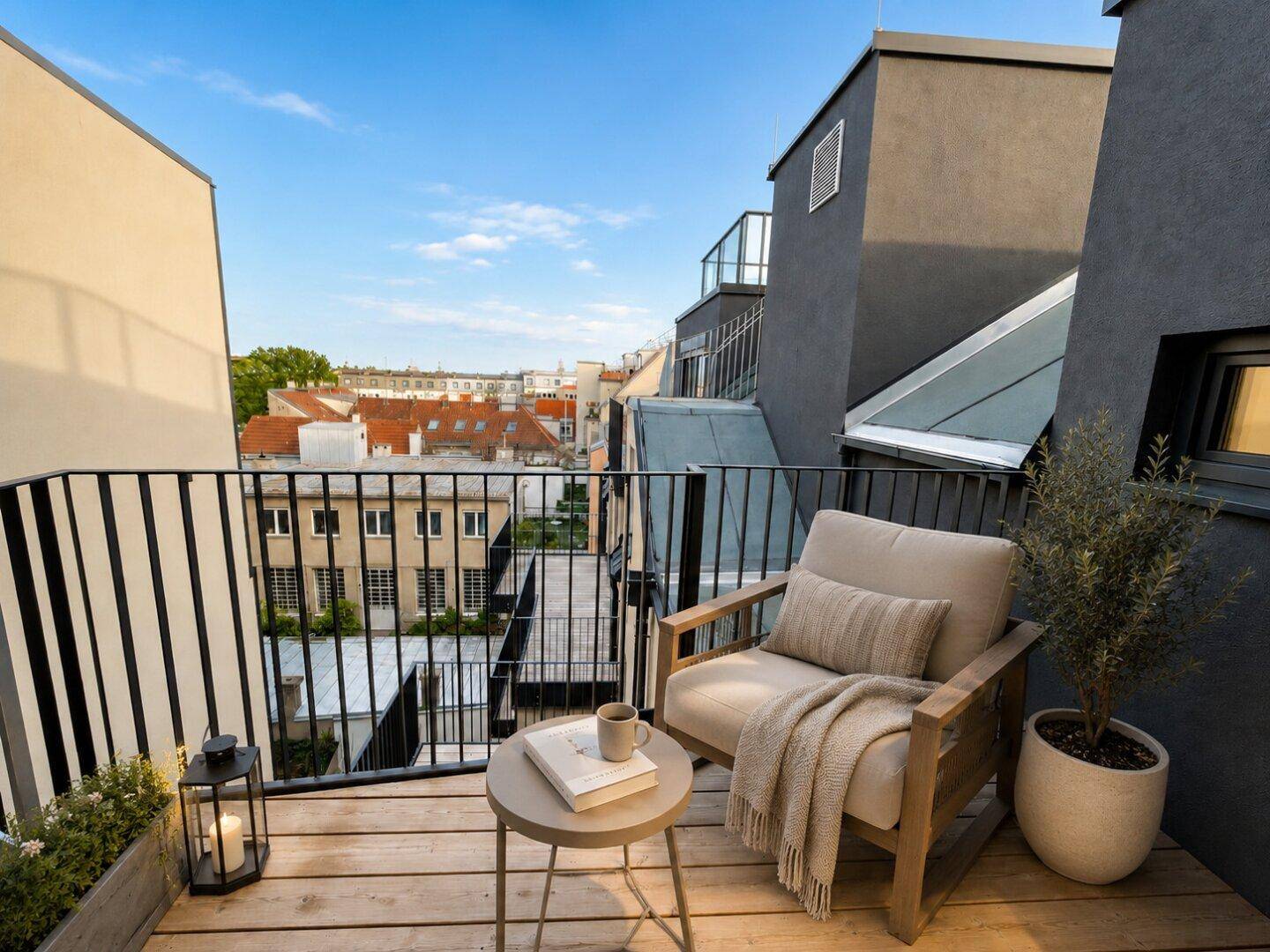 Kleiner, gemütlicher Balkon mit Sitzgelegenheit und Blick auf die umliegenden Dächer.