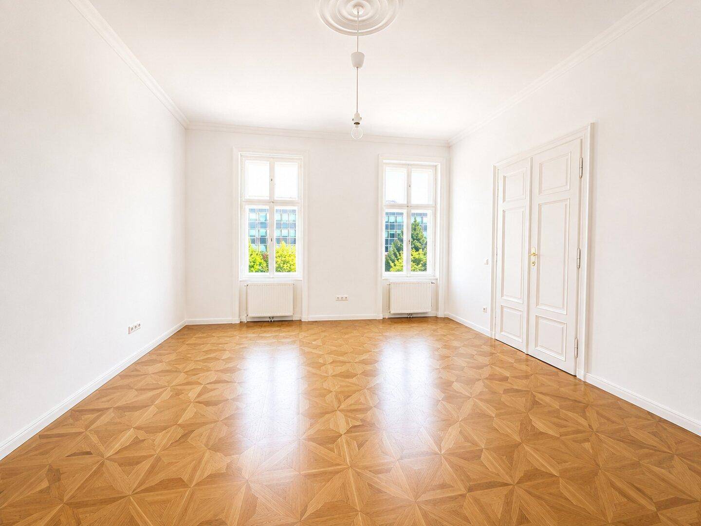 Lichtdurchflutetes Zimmer mit Parkettboden, hohen Decken und Stuckrosette, bietet vielseitige Einrichtungsmöglichkeiten.
